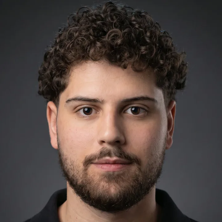 Portrait of Leonardo Kuster: curly dark hair, short beard, black polo shirt, dark background.